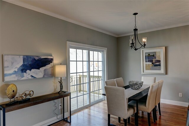 dining area with crown molding, a chandelier, and hardwood / wood-style floors