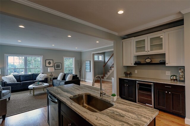 kitchen with light hardwood / wood-style flooring, wine cooler, ornamental molding, sink, and white cabinets