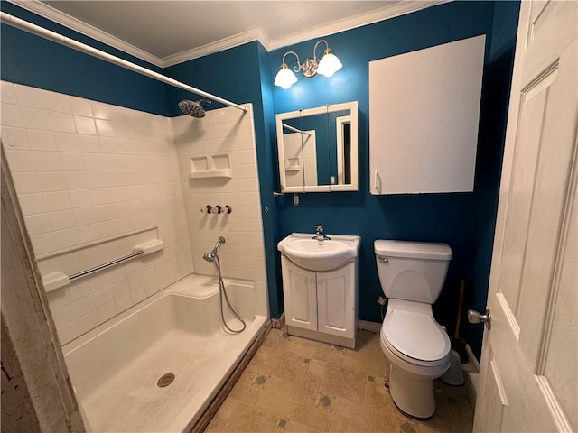 bathroom featuring vanity, crown molding, a tile shower, and toilet