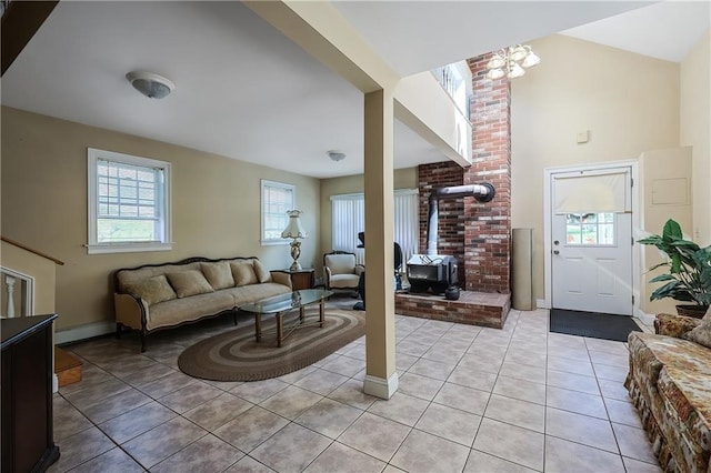 living room featuring an inviting chandelier, a baseboard heating unit, and light tile patterned floors