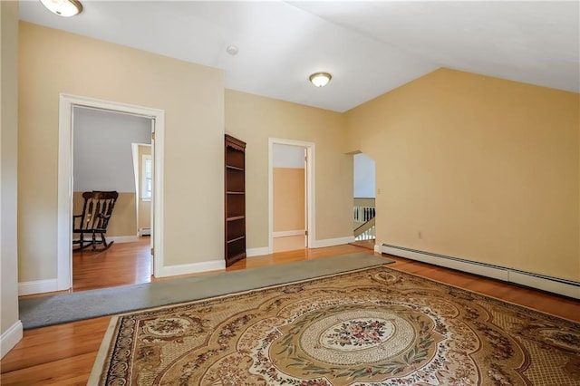 spare room with hardwood / wood-style flooring, lofted ceiling, and a baseboard radiator