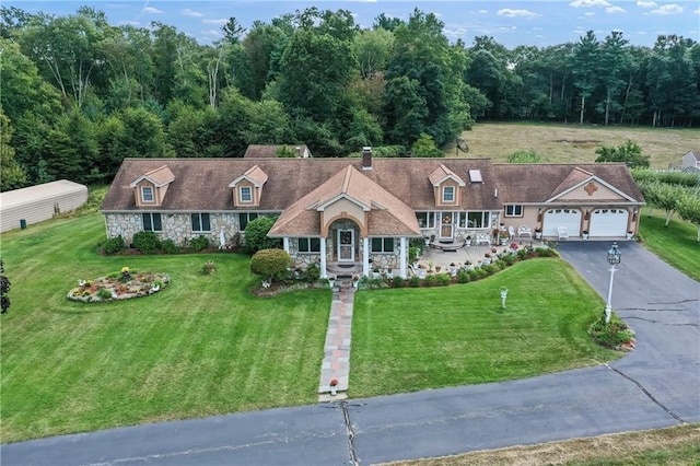 cape cod home with a front lawn and a garage