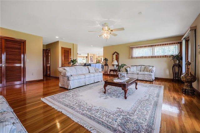 living room with wood-type flooring and ceiling fan