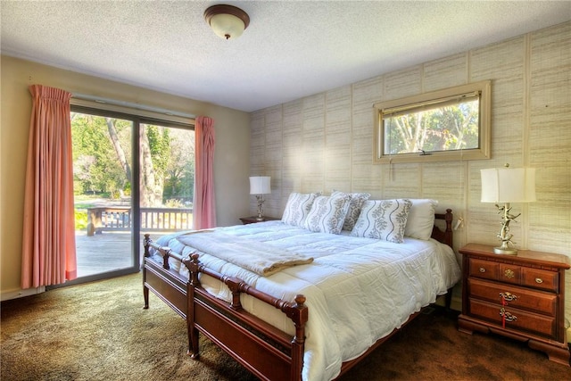 bedroom with a textured ceiling, access to outside, and dark carpet