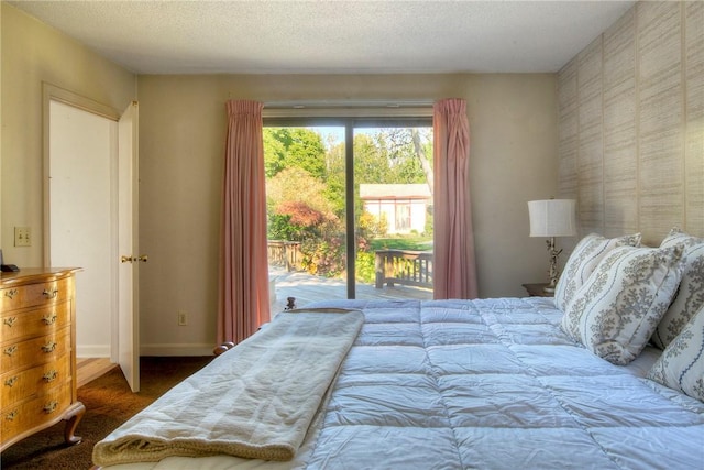 bedroom with a textured ceiling and access to exterior