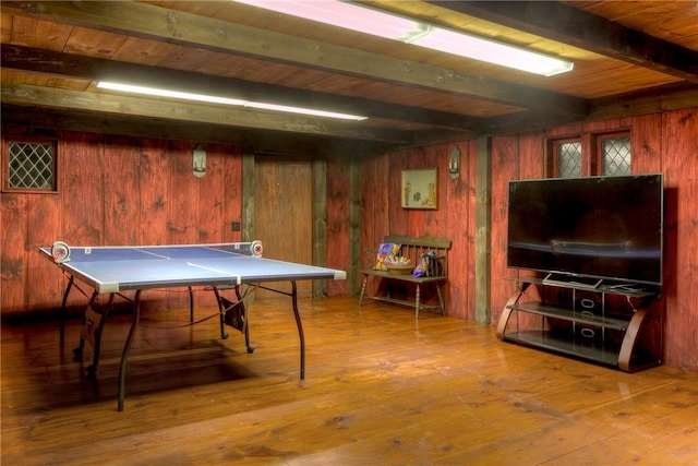 recreation room with beam ceiling, wood ceiling, wood walls, and wood-type flooring