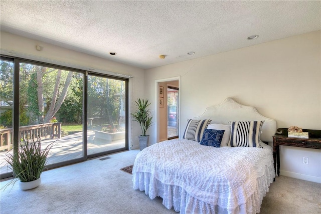 carpeted bedroom featuring a textured ceiling and access to outside