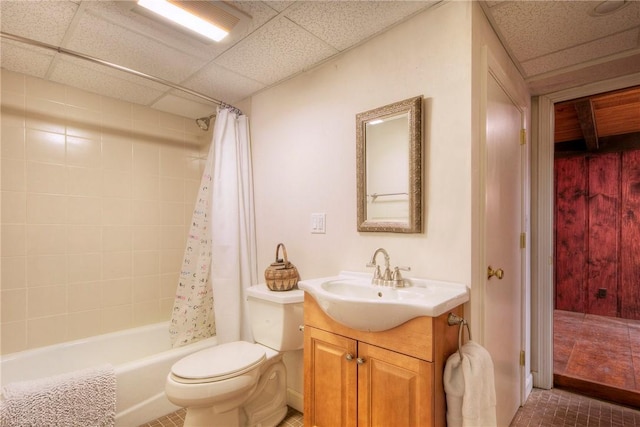 full bathroom featuring toilet, shower / bath combo, a paneled ceiling, and vanity