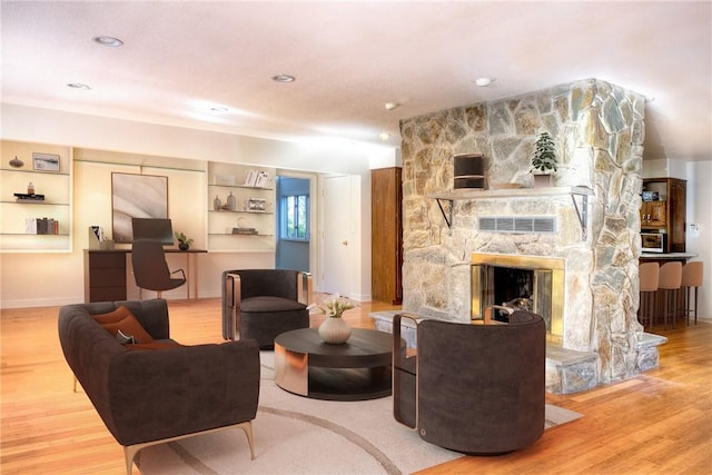 living room featuring hardwood / wood-style floors and a stone fireplace