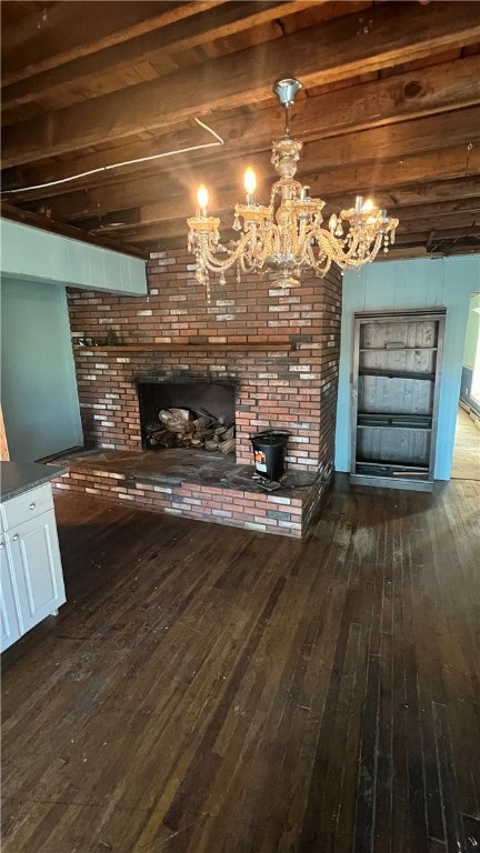 unfurnished living room featuring beamed ceiling, dark wood-type flooring, and a fireplace