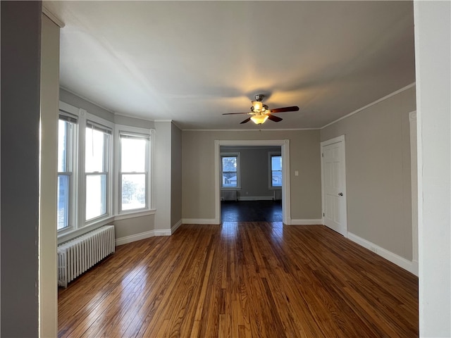 empty room with radiator, ceiling fan, crown molding, and dark hardwood / wood-style floors