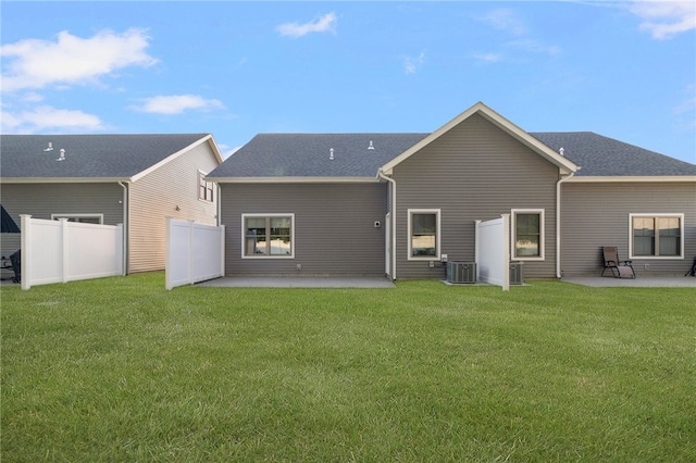 back of property featuring cooling unit, a patio area, and a lawn