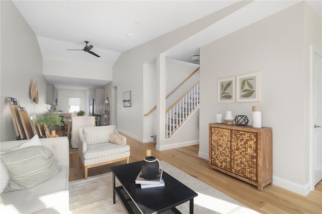 living room featuring light hardwood / wood-style floors, ceiling fan, and vaulted ceiling