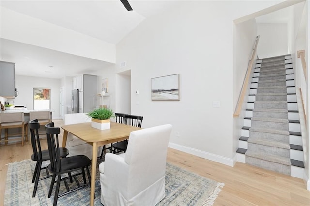 dining area with light hardwood / wood-style flooring and lofted ceiling