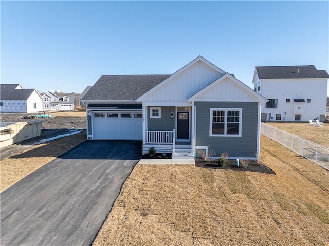 view of front of home featuring a garage, covered porch, and a front lawn