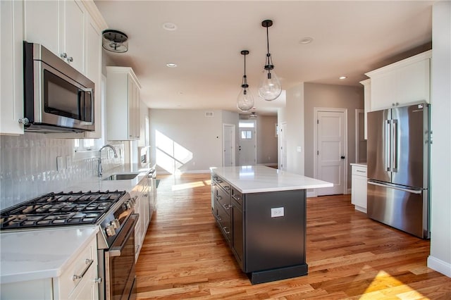 kitchen featuring stainless steel appliances, a center island, and white cabinets