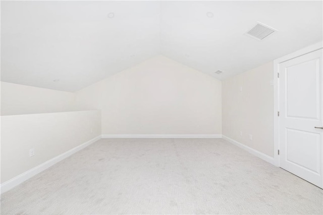 bonus room featuring light colored carpet and vaulted ceiling