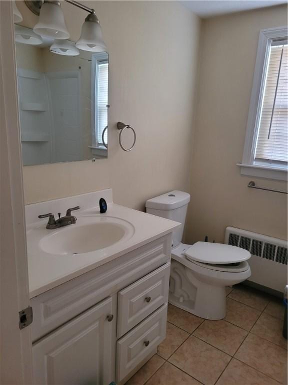 bathroom with tile patterned floors, vanity, toilet, and radiator heating unit