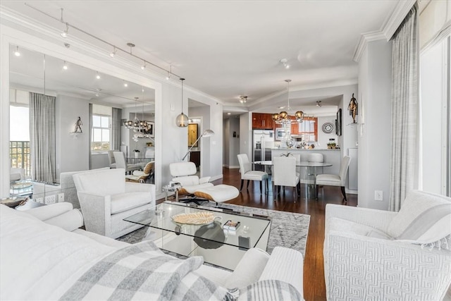 living room featuring crown molding, baseboards, an inviting chandelier, and wood finished floors