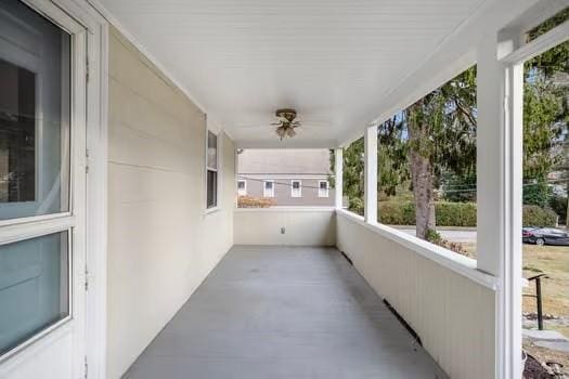 unfurnished sunroom featuring ceiling fan