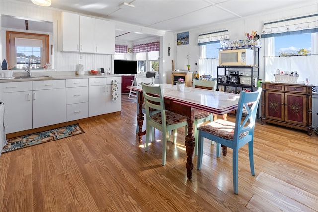 dining area featuring light hardwood / wood-style flooring, sink, and plenty of natural light