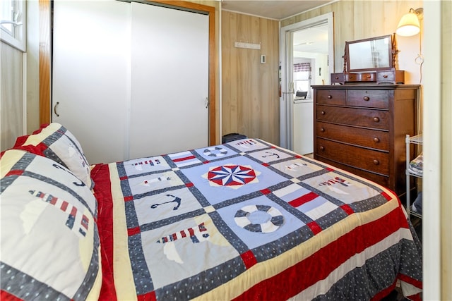 bedroom with a closet and wood walls