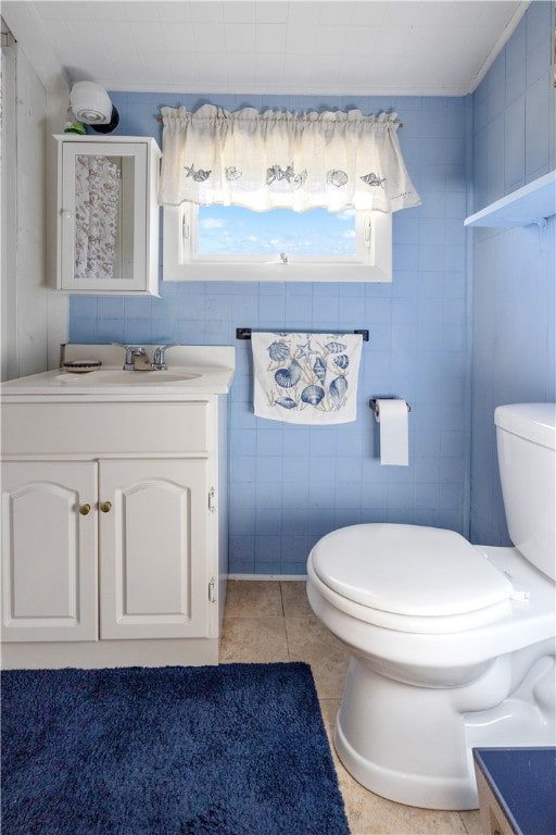 bathroom featuring vanity, toilet, tile walls, and tile patterned flooring