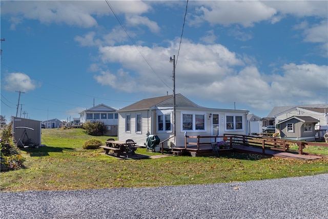 view of front facade with a deck and a front lawn