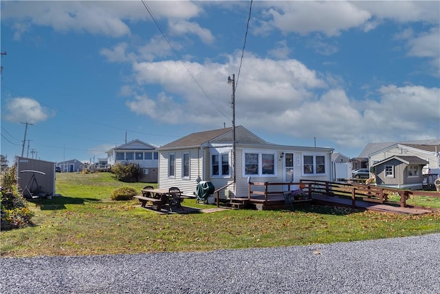 view of front of home featuring a front yard and a deck