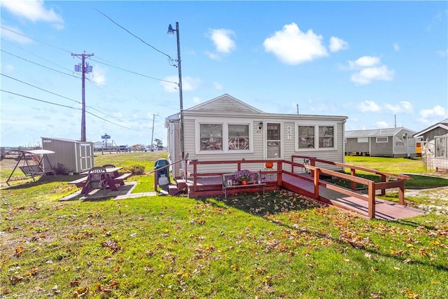 rear view of property featuring an outbuilding, a yard, and a shed