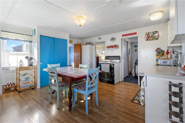 dining area with crown molding, sink, and wood-type flooring