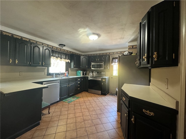 kitchen featuring appliances with stainless steel finishes, a textured ceiling, sink, and light tile patterned floors