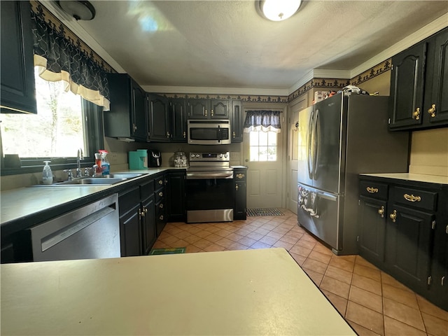 kitchen with stainless steel appliances, sink, crown molding, light tile patterned floors, and a textured ceiling