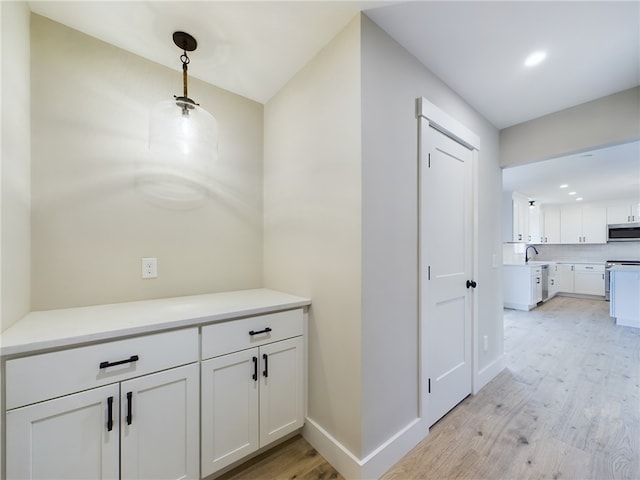 corridor featuring light hardwood / wood-style floors and sink