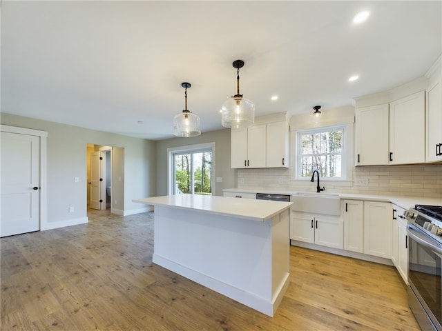 kitchen featuring white cabinetry, stainless steel appliances, backsplash, hanging light fixtures, and a center island