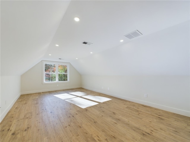 additional living space featuring lofted ceiling and light hardwood / wood-style floors