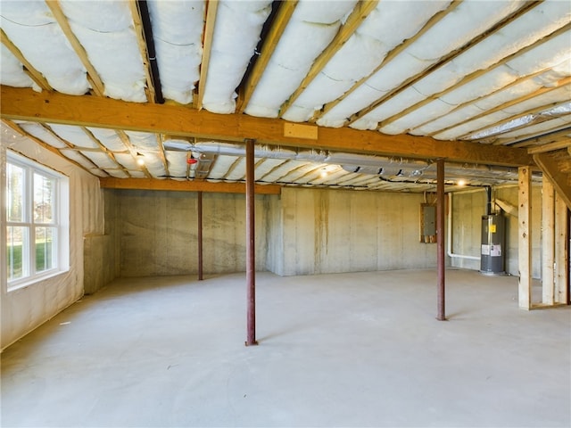 basement featuring electric panel and water heater