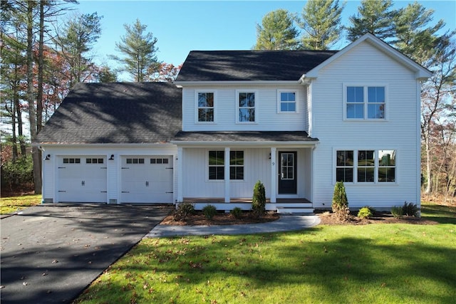 view of front of house featuring a front yard, a garage, and a porch