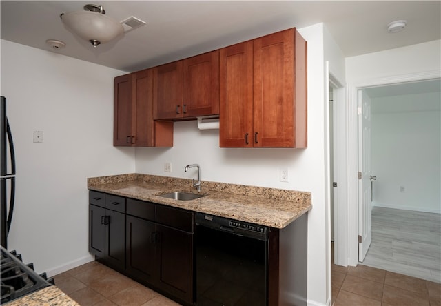 kitchen with light hardwood / wood-style floors, light stone countertops, black appliances, and sink