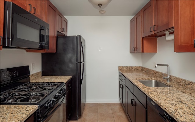 kitchen with sink, black appliances, light stone countertops, and light tile patterned floors