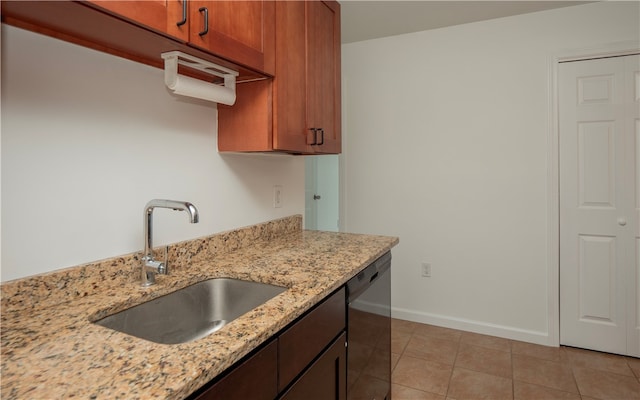 kitchen featuring sink, light stone countertops, dishwasher, and light tile patterned floors