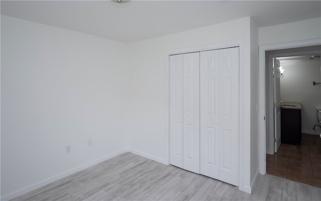 unfurnished bedroom with a closet and light hardwood / wood-style floors