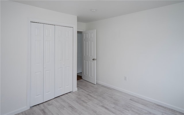 unfurnished bedroom with a closet and light hardwood / wood-style flooring