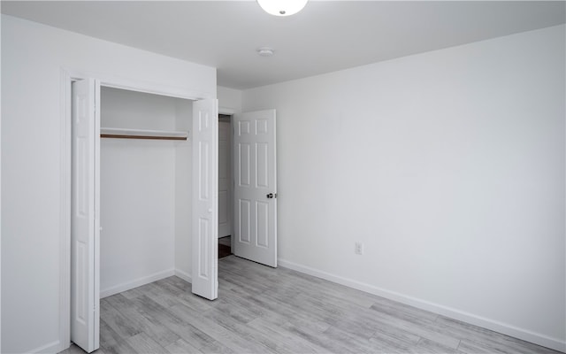 unfurnished bedroom featuring a closet and light wood-type flooring