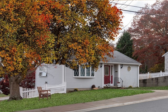 view of property hidden behind natural elements featuring a front yard