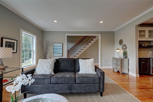 living room featuring light hardwood / wood-style flooring, ornamental molding, and beverage cooler