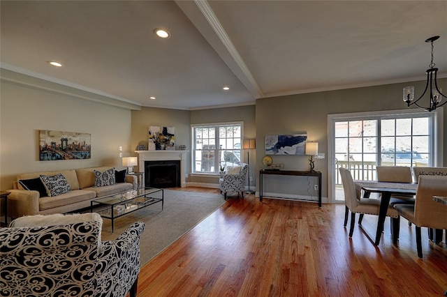 living room with crown molding, a notable chandelier, and wood-type flooring