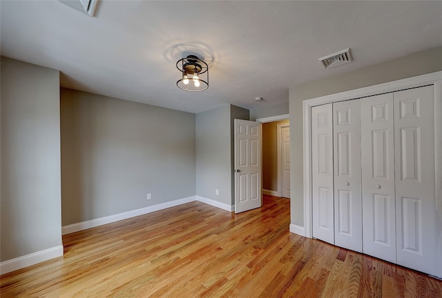 unfurnished bedroom with a closet and light wood-type flooring