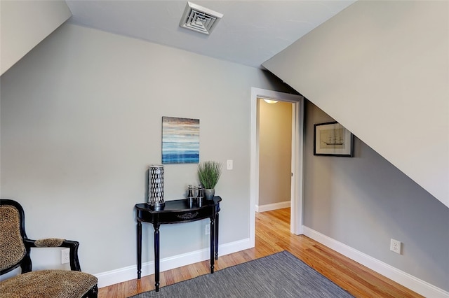 living area with light hardwood / wood-style floors and vaulted ceiling