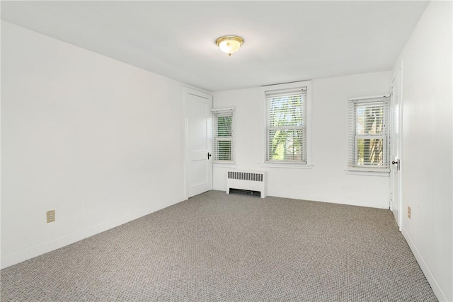 unfurnished room featuring carpet flooring and radiator